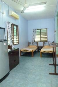 - un salon avec deux lits et un réfrigérateur dans l'établissement Cheers Garden Chalet, à Kampung Tekek