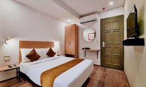 a hotel room with a large bed and a television at FabHotel Lupin Internation in Udaipur