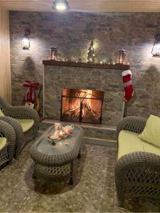 a living room with a fireplace with a christmas tree at კოტეჯი ბახმაროში WoodenHouse Sunrise in Bakhmaro