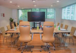 a conference room with a large table with chairs and a projection screen at Ramada by Wyndham Downtown Dubai in Dubai +227 photos