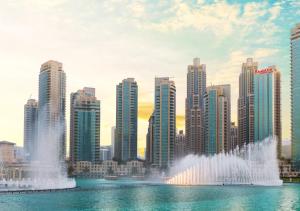 a city with a fountain in the water with buildings at Ramada Downtown Dubai in Dubai