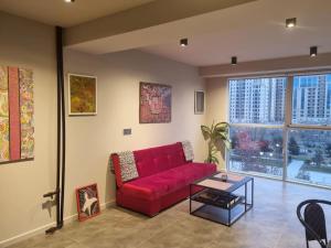 uma sala de estar com um sofá vermelho e uma mesa em Art Studio Park View 53 em Baku