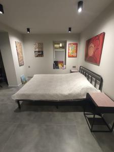 um quarto com uma cama grande e pinturas na parede em Art Studio Park View 53 em Baku