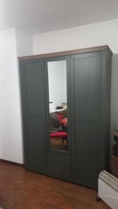 einen grauen Schrank mit einem roten Stuhl in einem Zimmer in der Unterkunft CASA DEL MAESTRO in Castel di Lama