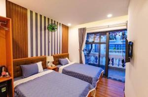 Habitación de hotel con 2 camas y balcón en KHÁCH SẠN TRE VIỆT 2, en Tuy Hoa