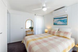 a bedroom with a bed with a checkered blanket at Bahia 1 Newly renovated unit with Filtered Water Views in Shoal Bay