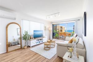 a living room with a couch and a tv at Bahia 1 Newly renovated unit with Filtered Water Views in Shoal Bay