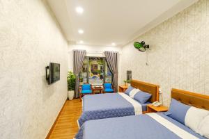 1 dormitorio con 2 camas, mesa y sillas en KHÁCH SẠN TRE VIỆT 2, en Tuy Hoa