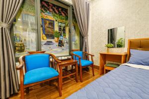 1 Schlafzimmer mit einem Bett, 2 Stühlen und einem Schreibtisch in der Unterkunft KHÁCH SẠN TRE VIỆT 2 in Tuy Hoa