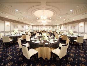 a banquet room with tables and chairs and a chandelier at Hotel Awina Osaka in Osaka