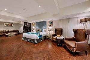 シムラーにあるMarina- Shimla First Designer Boutique Hotelのベッドと椅子付きのホテルルーム