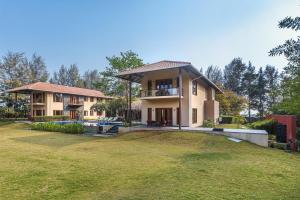 a house with a large yard in front of it at SaffronStays Courtyard, Nashik - infinity pool villa with a huge party lawn in Nashik