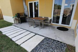 a patio with a table and chairs next to a house at Aventura Home by Flatsaway in Aventura