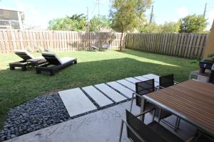 a backyard with a table and chairs and a fence at Aventura Home by Flatsaway in Aventura