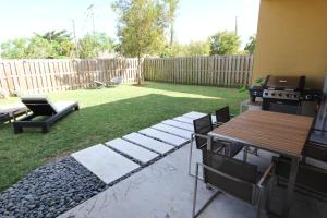 a backyard with a grill and a table and chairs at Aventura Home by Flatsaway in Aventura