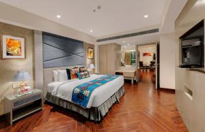 a bedroom with a large bed and a living room at Marina- Shimla First Designer Boutique Hotel in Shimla