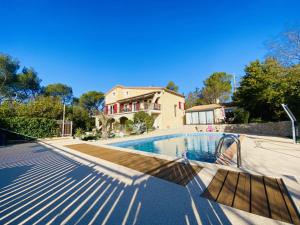 a house with a swimming pool in front of a house at Les Gites du Mas des Cigales in Nîmes