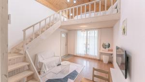 a living room with a staircase and a tv at Tinkerbell Pension in Gyeongju