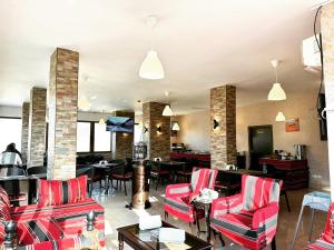 a lobby with red chairs and tables and a restaurant at Anbat Midtown Hotel in Wadi Musa