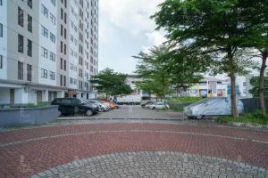 a brick road with cars parked in a parking lot at RedLiving Apartemen 19 Avenue - Amanah Room in Tangerang