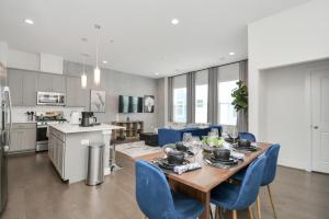 a kitchen and dining room with a table and blue chairs at Casa Azure - New Modern 3 BR, Med Center, NRG, UH in Houston