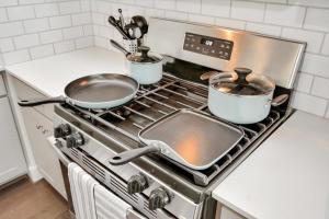 a kitchen stove with two pots and pans on it at Casa Azure - New Modern 3 BR, Med Center, NRG, UH in Houston
