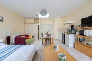 ein Schlafzimmer mit einem Bett, eine Küche und ein Wohnzimmer in der Unterkunft L'Arbre Rouge & L'Arbre Vert in Jonzac
