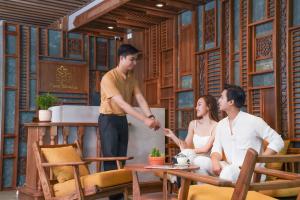 峴港的住宿－Bonny Boutique Hotel Da Nang，站在两个人之间,在屋子里的一个男人