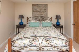 a bedroom with a bed with two blue lamps at Breakish Cottage in Breakish