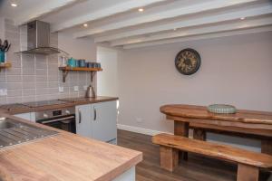 a kitchen with a wooden table and a counter top at Breakish Cottage in Breakish