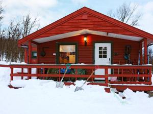 a red cabin with snow in front of it at Holiday home Kokelv II in Kokelv
