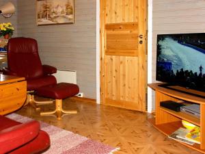 a living room with a chair and a television at Holiday home Kokelv II in Kokelv
