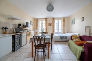 eine Küche und ein Wohnzimmer mit einem Tisch und einem Sofa in der Unterkunft L'Arbre Rouge & L'Arbre Vert in Jonzac