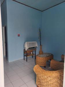 NKR Guest House في Pagaralam: غرفة بطاولة وكراسي وبيانو