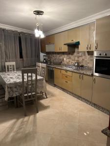 uma cozinha com uma mesa e uma sala de jantar em Duplex haut standing à 5min de la plage2 em Agadir