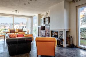 ein Wohnzimmer mit orangefarbenen Stühlen und einem Kamin in der Unterkunft Villa Il Poggino - Modern House in Foiano della Chiana