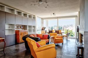 ein Wohnzimmer mit einem Sofa, Stühlen und einem Tisch in der Unterkunft Villa Il Poggino - Modern House in Foiano della Chiana
