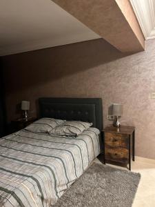una camera con un letto e due comodini con lampade di Duplex haut standing à 5min de la plage2 ad Agadir