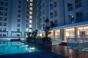a swimming pool in front of a building at night at Skyland City Hotel Jatinangor in Jatinangor