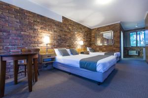 a bedroom with two beds and a brick wall at Montville Mountain Inn in Montville