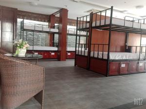 a room with two bunk beds with a table and a tableablishangering at Catba Central Hostel in Cat Ba