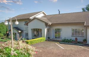 a house with a brick driveway in front of it at Hillwatering Country House in Sabie