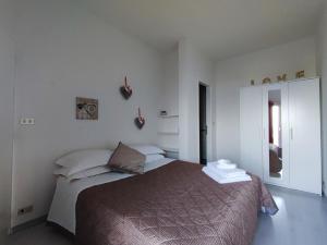 1 dormitorio con 1 cama en una habitación blanca en Sirmione Sunrise Lake View en Sirmione