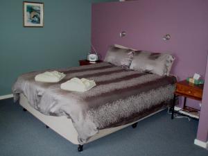 a bedroom with a bed with two towels on it at Highland Cabins and Cottages at Bronte Park in Bronte