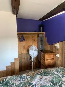 1 dormitorio con cama y pared azul en Gîte La Valette d'Aurore - animaux bienvenus, 