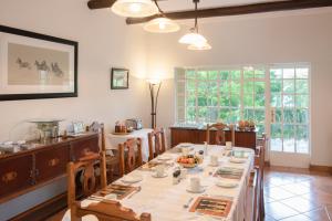 uma sala de jantar com uma mesa longa e cadeiras em Hillwatering Country House em Sabie