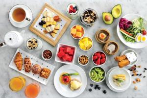 a table with plates of food and cups of coffee at JW Marriott Hotel Hong Kong in Hong Kong