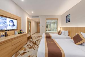 a hotel room with two beds and a flat screen tv at The Reed Hotel in Ninh Binh +119 photos
