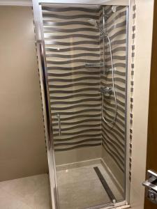 a shower with a glass door in a bathroom at Duplex haut standing à 5min de la plage2 in Agadir