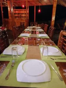 une grande table avec des assiettes et des fourchettes blanches et des couches dans l'établissement The Peak Ella, à Ella